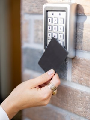 Attaching card to the electronic reader to access the office or apartment, close-up. Card entry, personal identification, keyless access, modern technologies concept